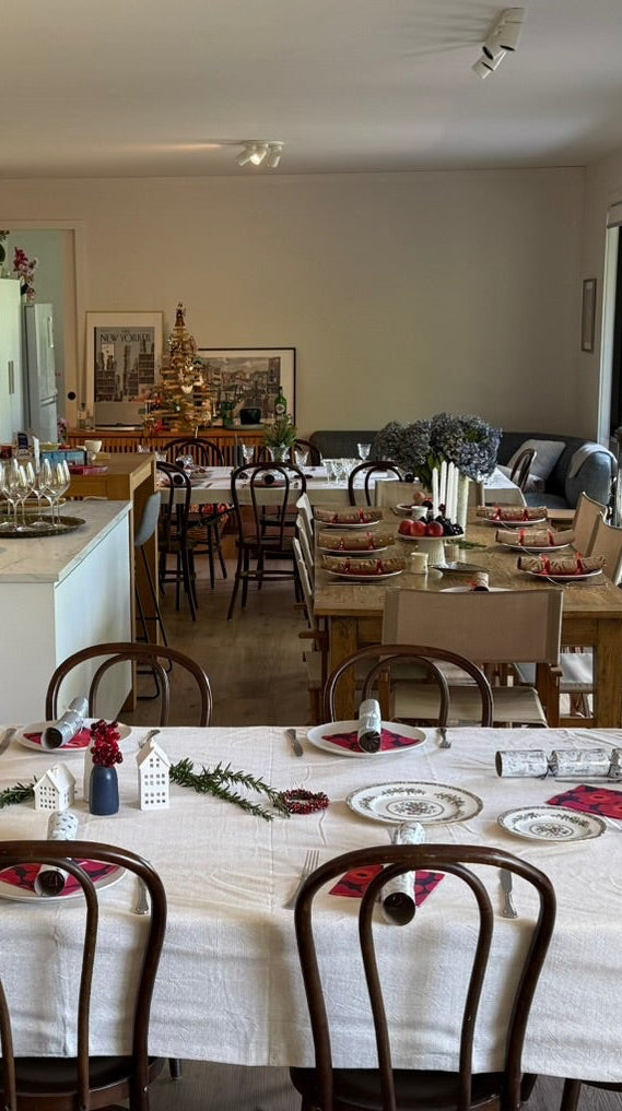 Dining room with tables set for a meal, chairs, and decorative elements.
